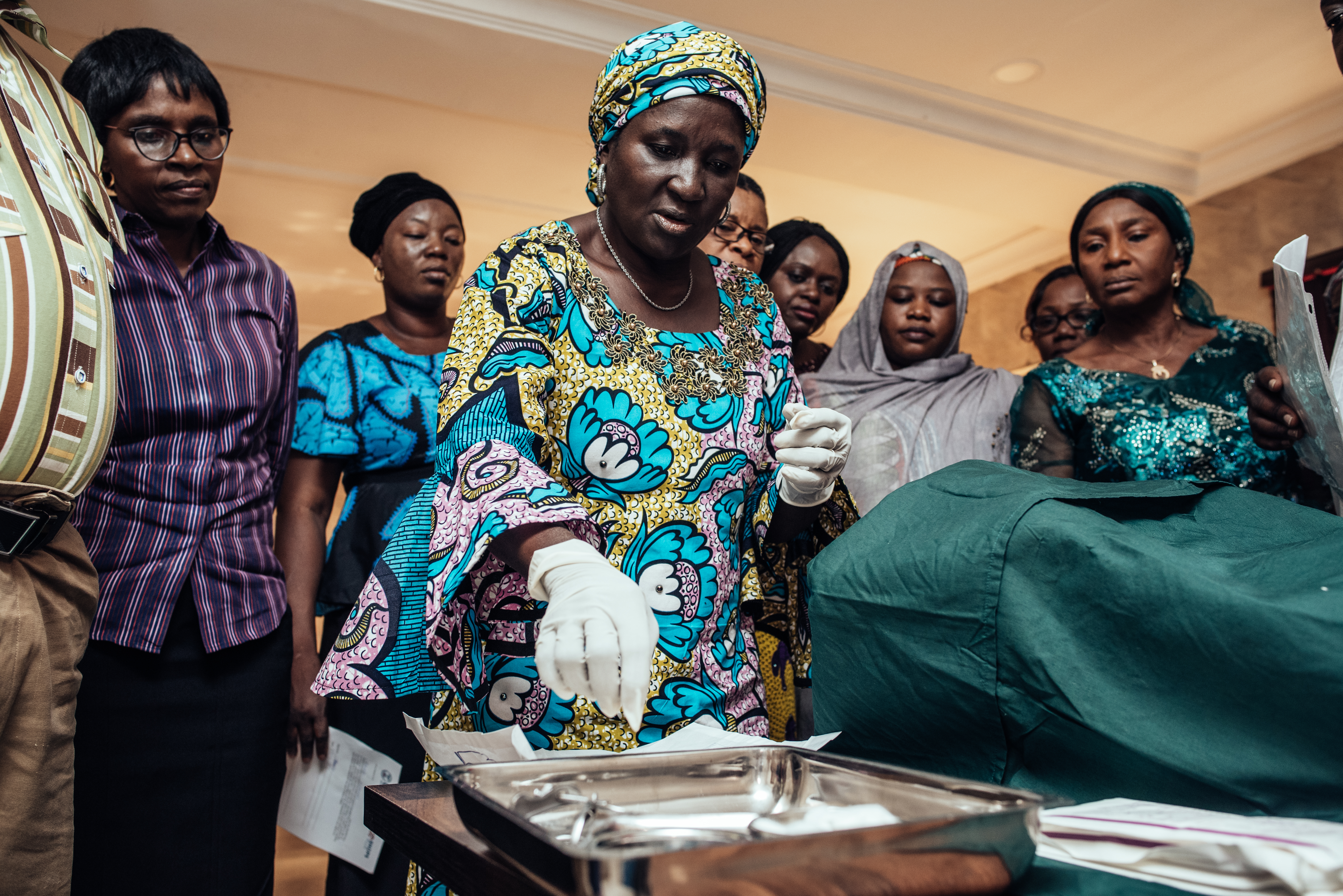 TA health provider in Nigeria uses a model to practice inserting an IUD as her fellow trainees watch.