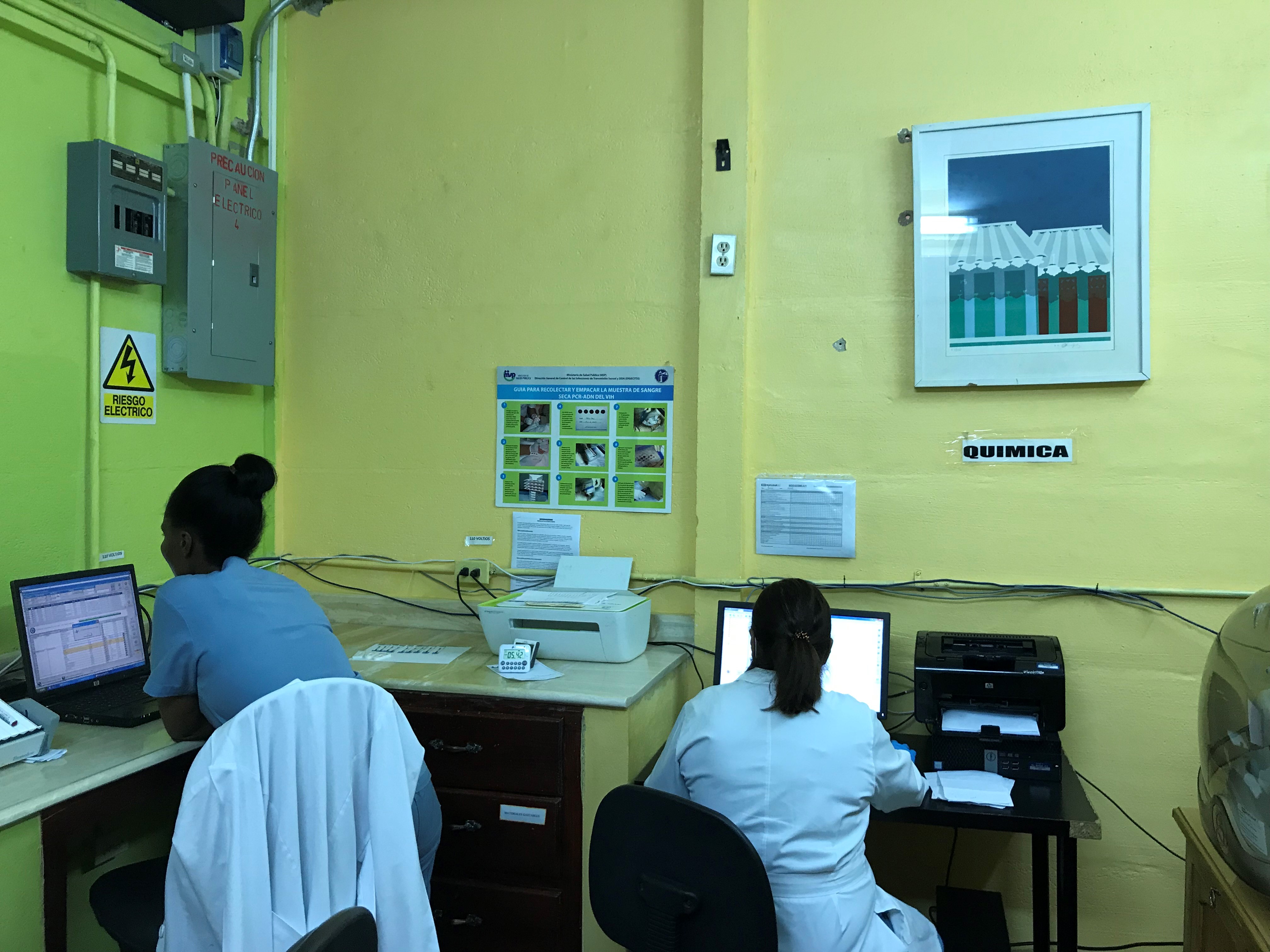 Two lab technicians entering data manually at La Clinica de Familia. 