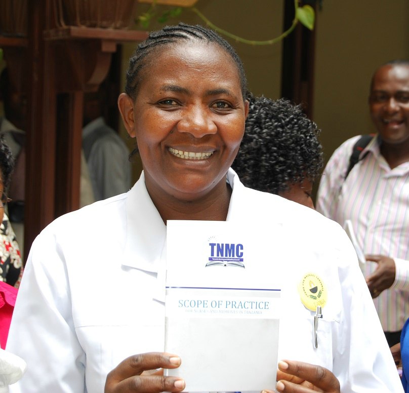 Esther Mshubi, R.N. and assistant matron for Hindu Mandal Hospital in Dar es Salaam, holds a printed copy of the scope of practice in 2014.