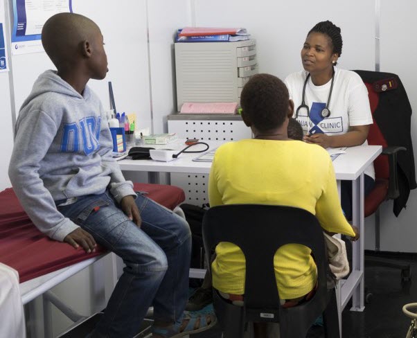 A woman and her son consult with a female health provider
