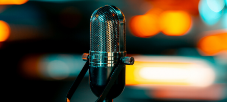Image of a microphone with blurred lights in the background