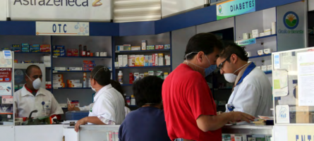 Image of a busy pharmacies with people wearing masks