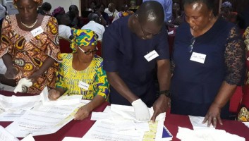 Four participants look through material at a family planning training session in Nigeria