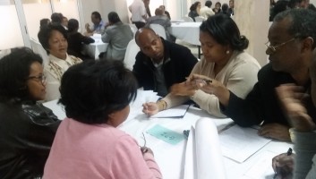 Participants in the workshop sit around a table during a breakout session. 