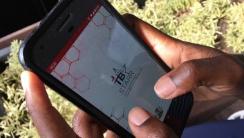 Person holding a phone with the TB STARR app on the screen. 