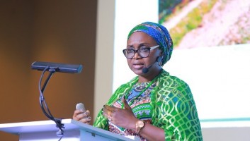 Amina Aminu talking from a podium at the conference