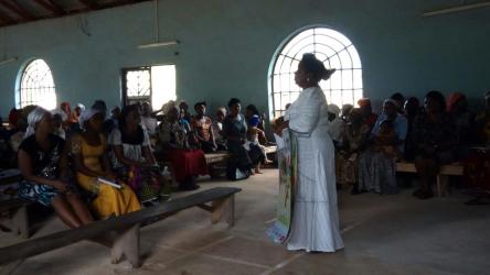 Woman speaking to large group in a church in Nigeria