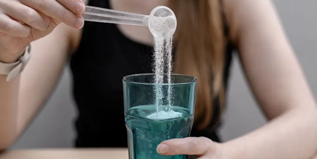 Person schüttet Pulver in ein Glas Lithium Orotate